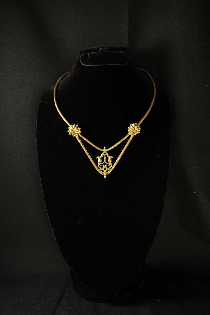 Gold necklace on a black stand against a black background